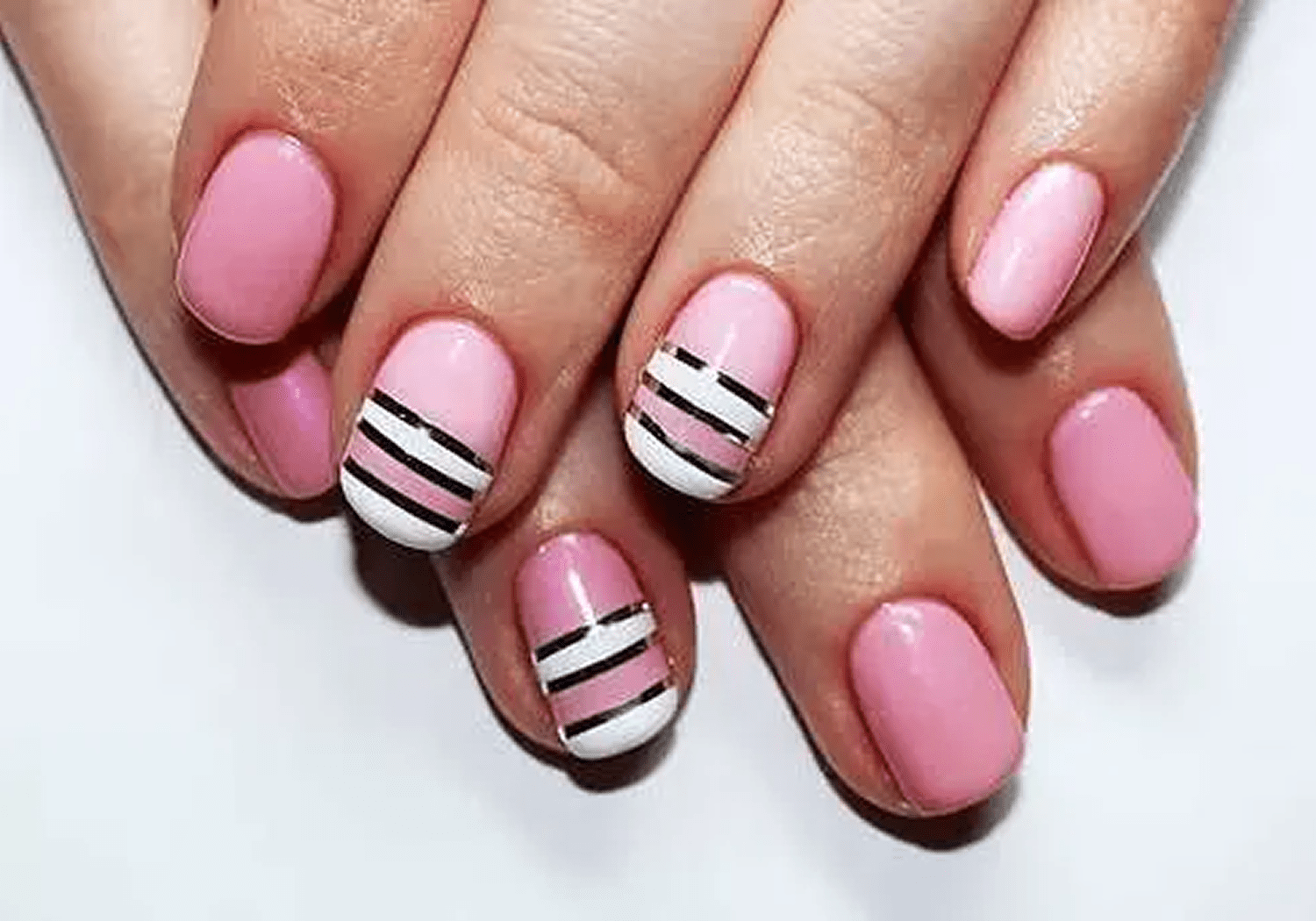Pink nails featuring black and white stripes