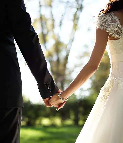 Couple in wedding attire holding hands