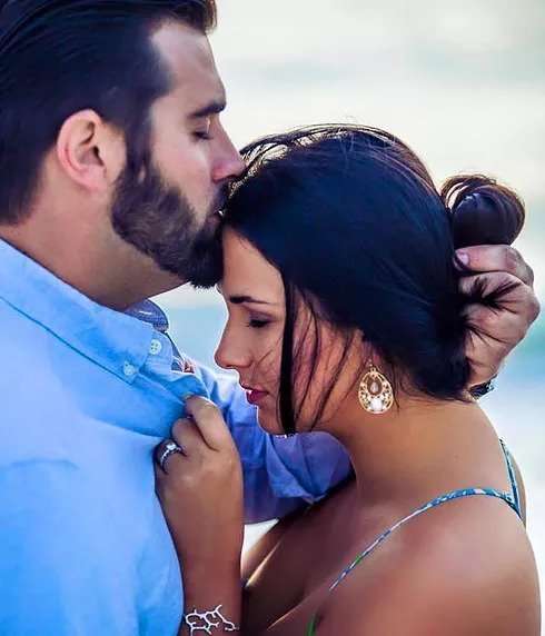 Man kissing woman's forehead