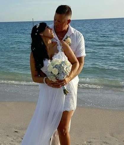 Bride and groom embracing on beach