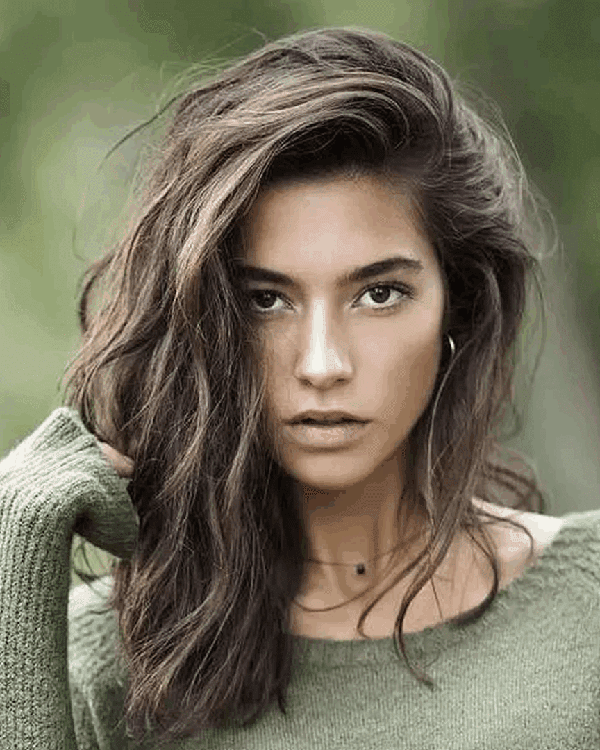 Stylish woman with wavy brown hair.